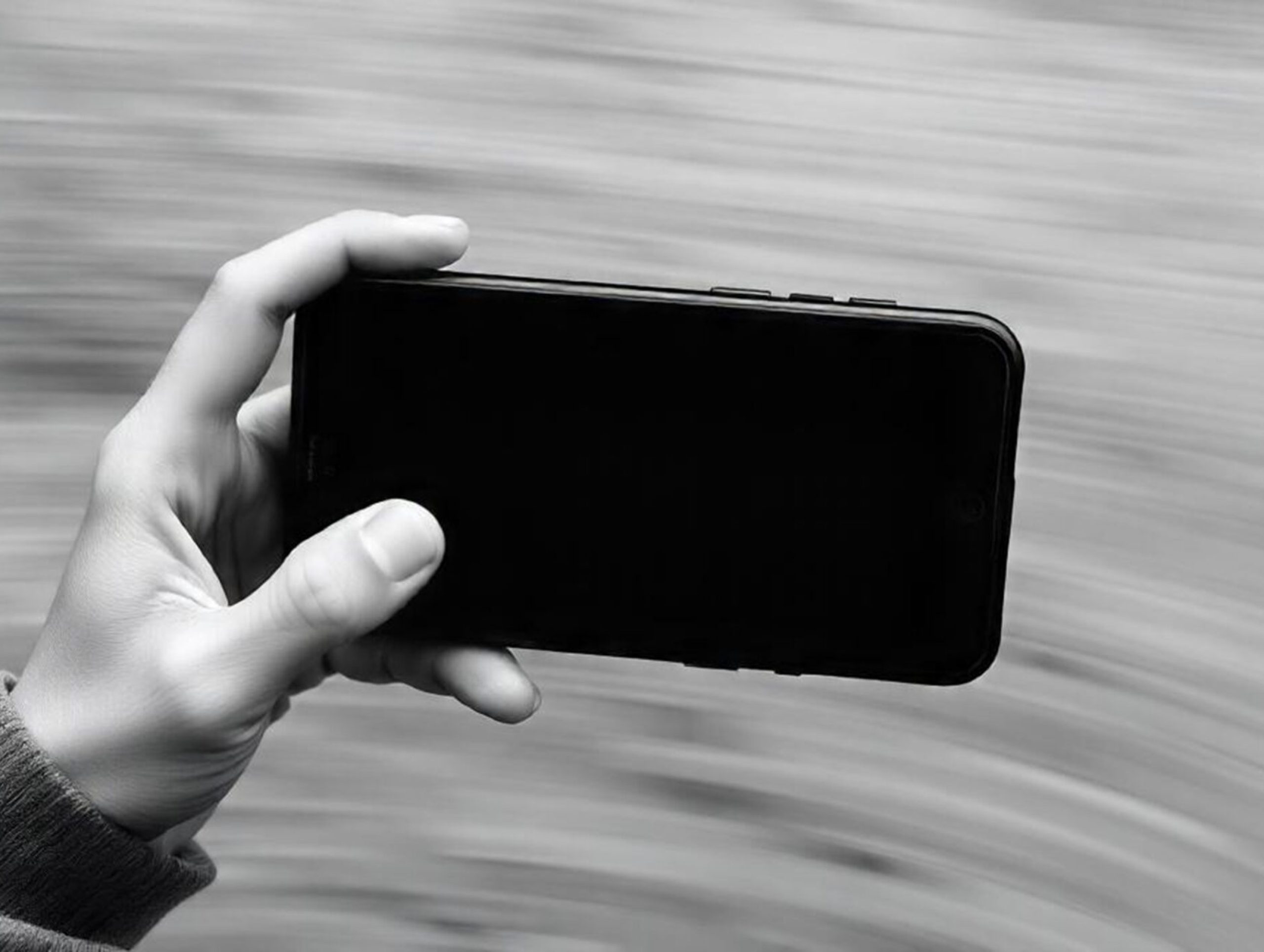 persons_hands_holding_black_smartphone_with_blank_white_screen-1-scaled.jpg